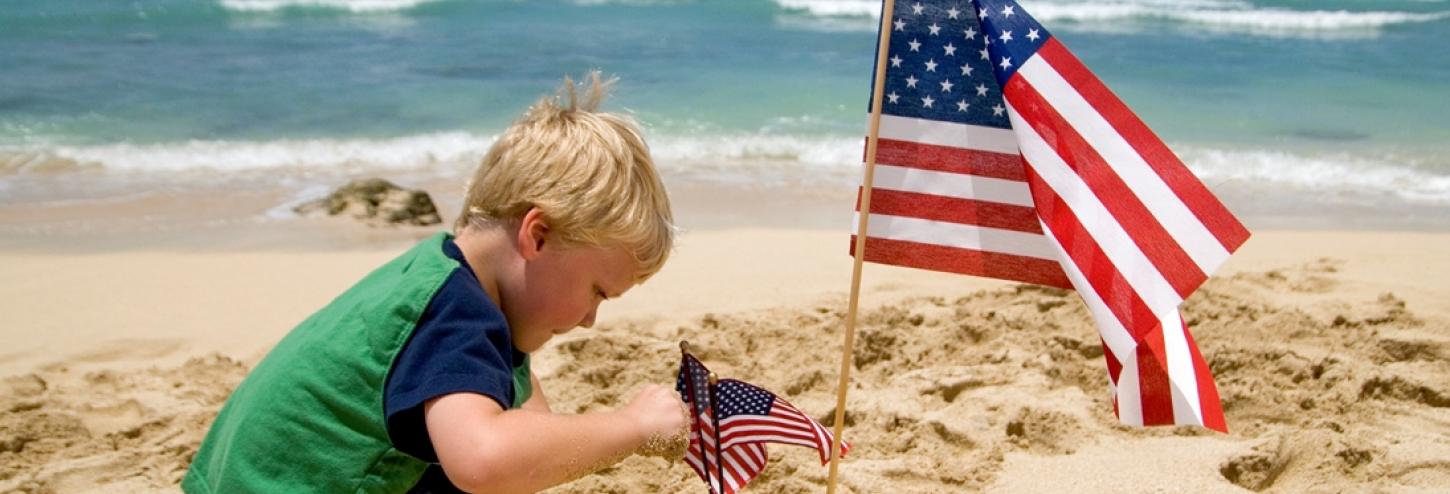 Boy and American flag on the beach