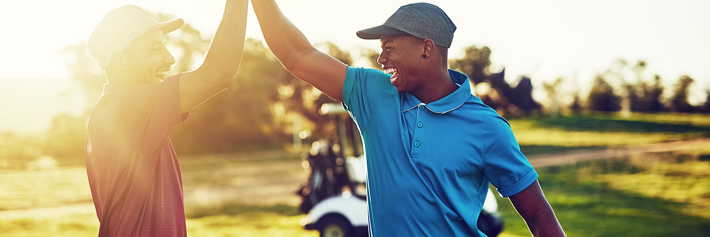 Two guy friends high-fiving over a round of golf